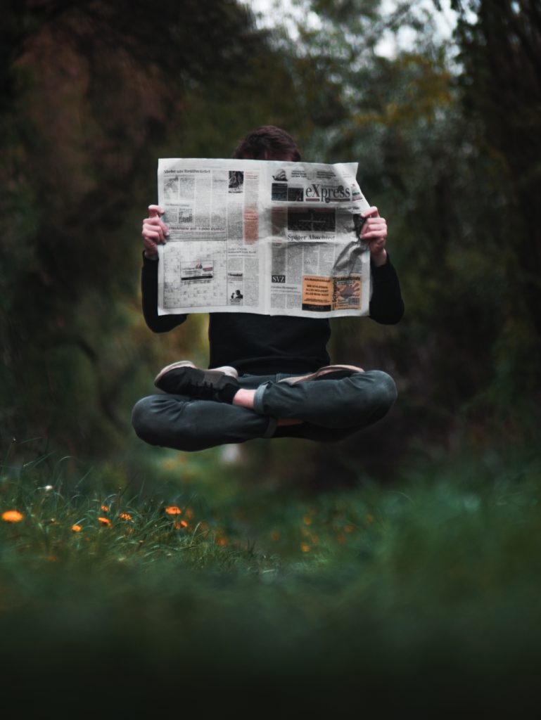 levatating person reading newspaper