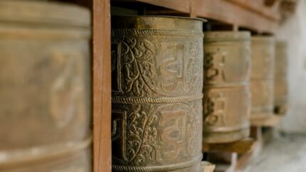 old prayer wheels with ornament in buddhist temple