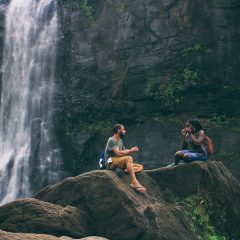 man and woman near waterfall
