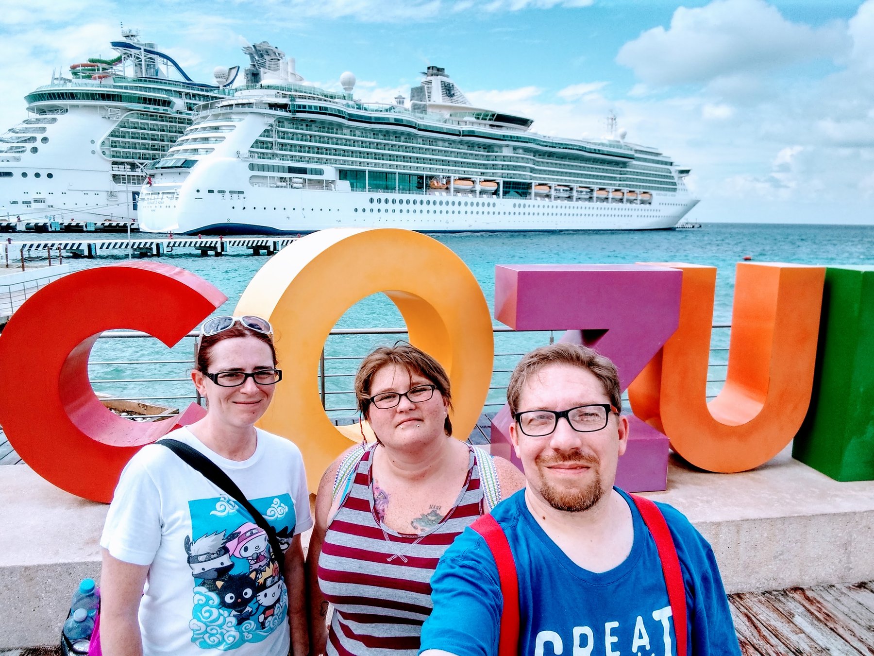 Joe and family at the Cozumel sign with Serenade of the Seas behind them.